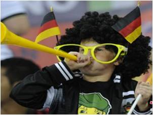 German child football fan in costume and blowing vuvuzela